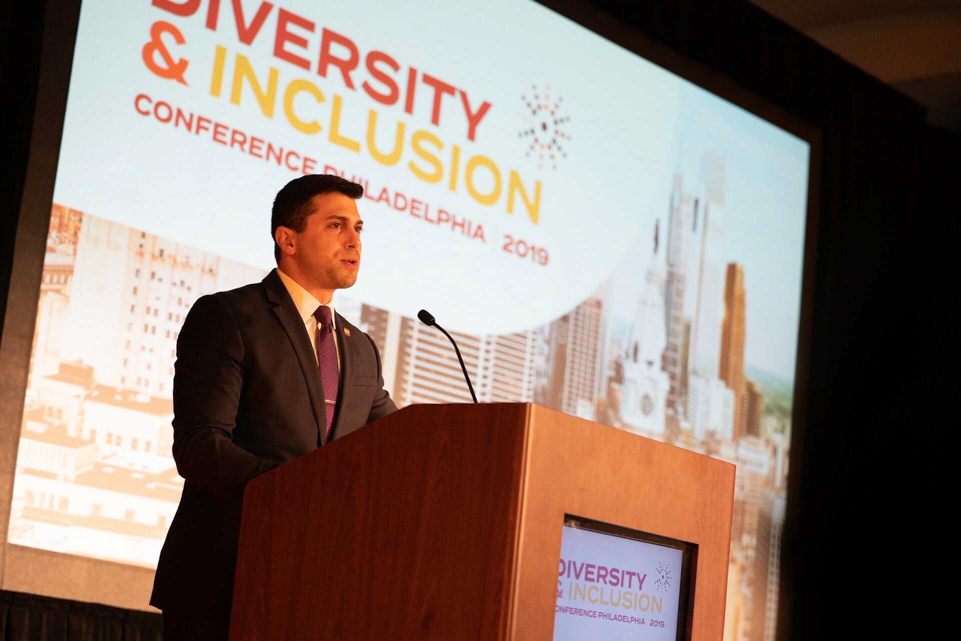 Jonathan Lovitz behind a podium, speaking at the Diversity and Inclusion conference in Philadelphia